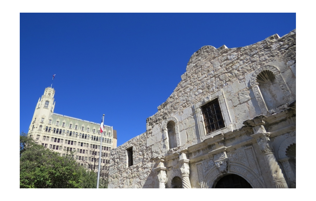 The Alamo with another large building behind it.
